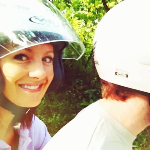 Man and woman wearing helmets on a motor bike.