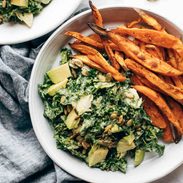 Avocado Kale Caesar Salad on a plate with sweet potato fries.