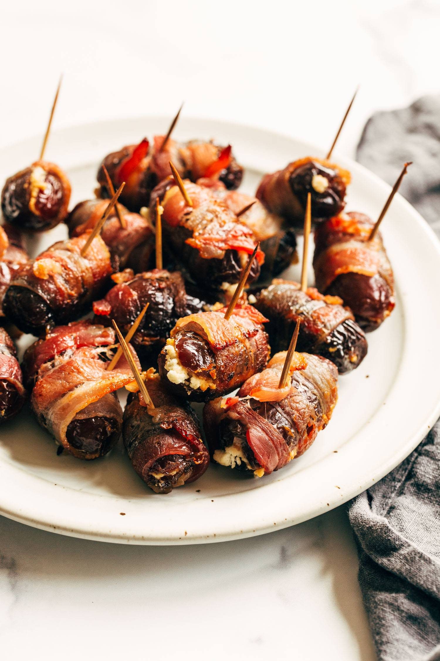 Bacon wrapped dates on a plate.