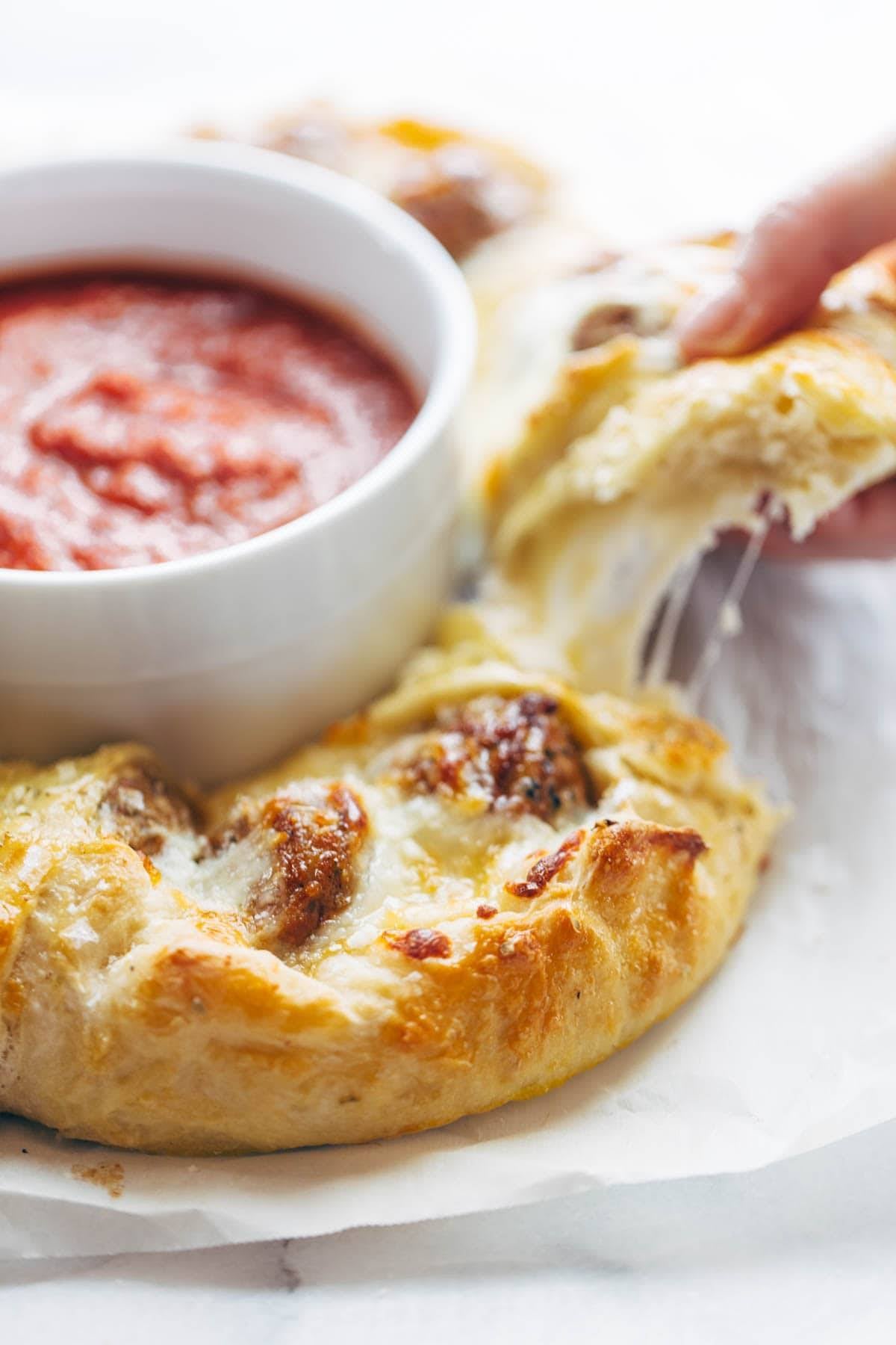 Cheesy Meatball Pull-Apart Pizza Ring with a bowl of marinara sauce