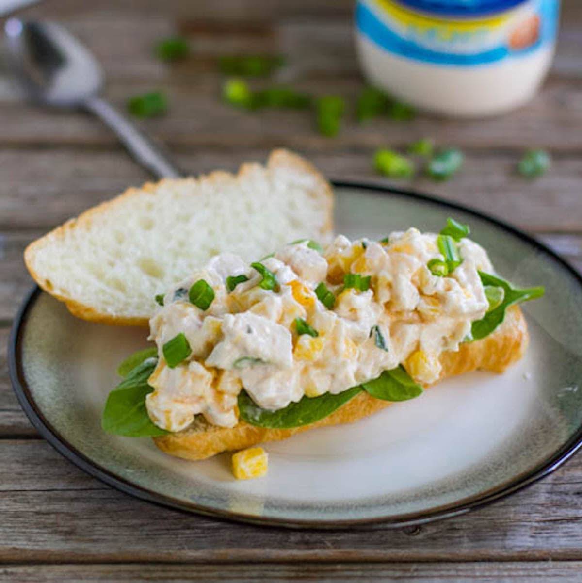 Mango chicken salad sandwich on a late.