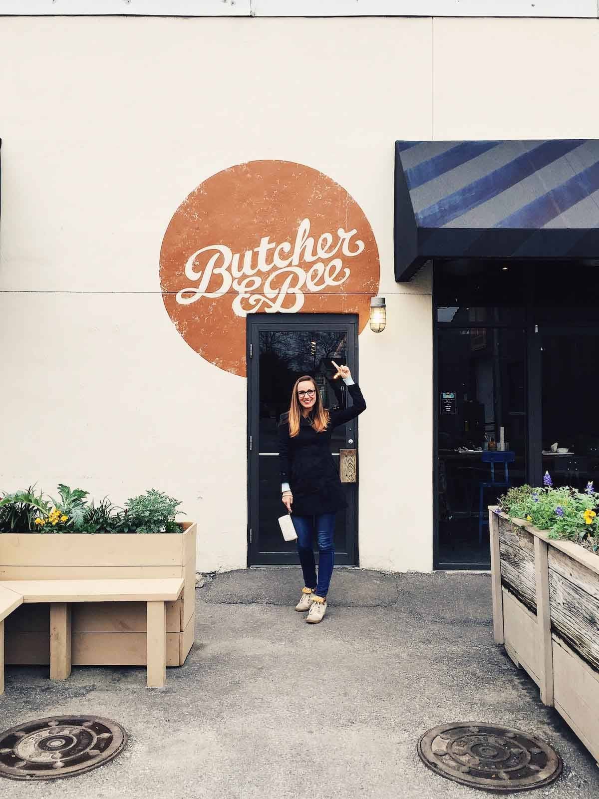 Butcher and bee sign with a woman pointing to it.